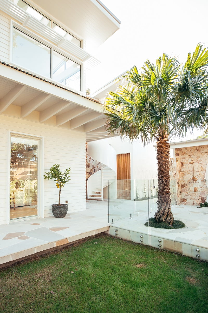 Exterior windows on white house with palm tree