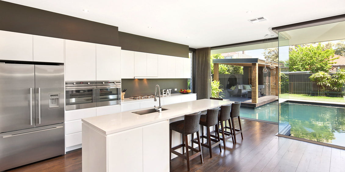 Kitchen floor to ceiling windows looking out to garden pond