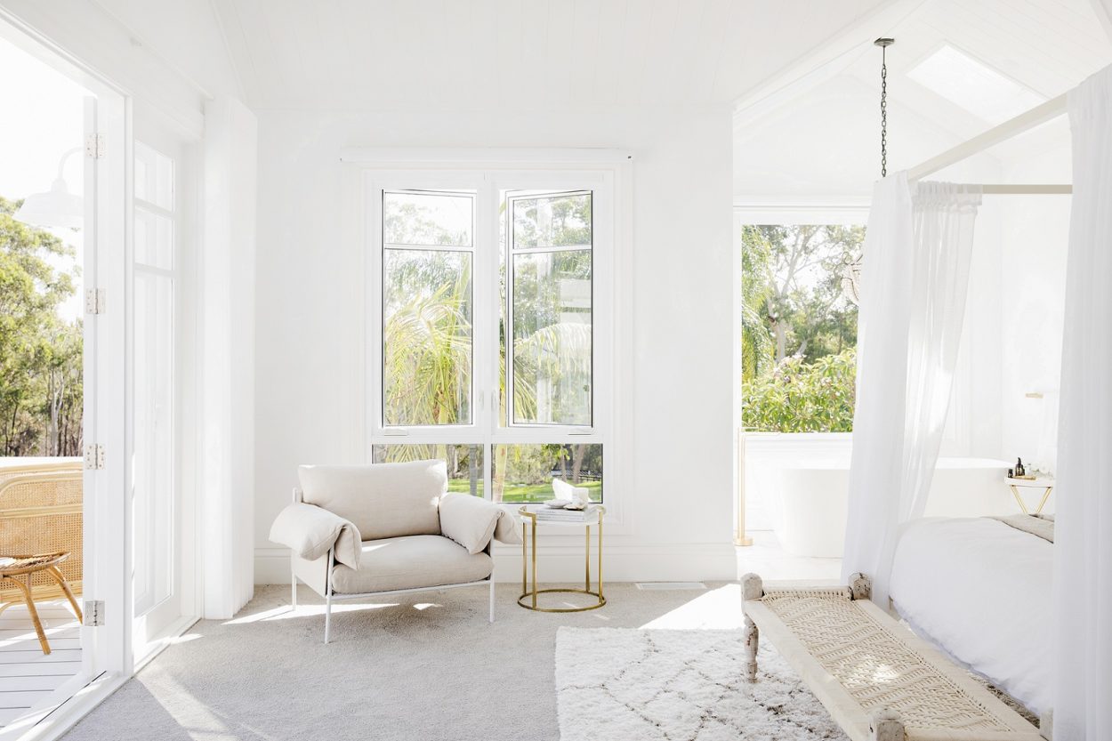White lounge with large windows and doors to outside