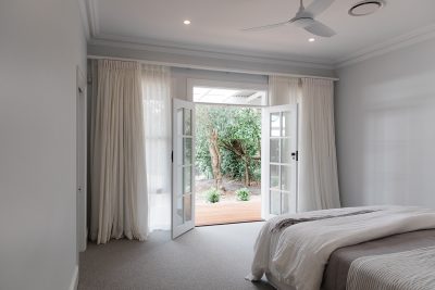 Bedroom with double doors open to garden