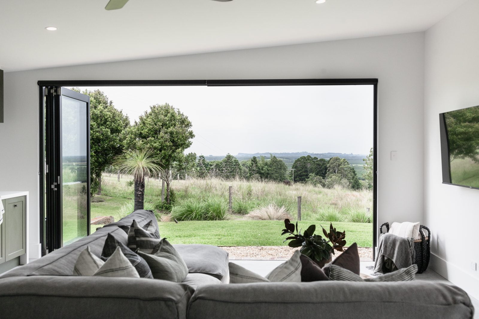 Living room with doors opened, providing a view to a natural environment