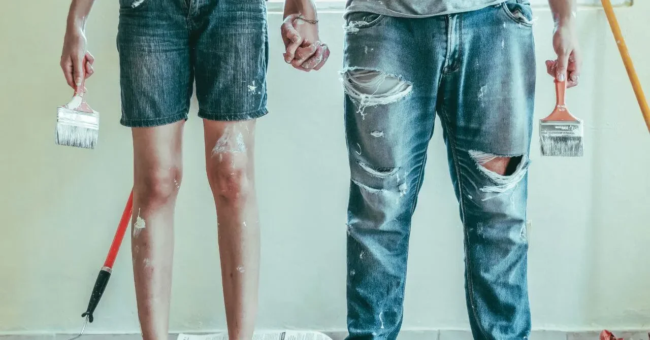 A couple with their clothes and skin dirty with paint